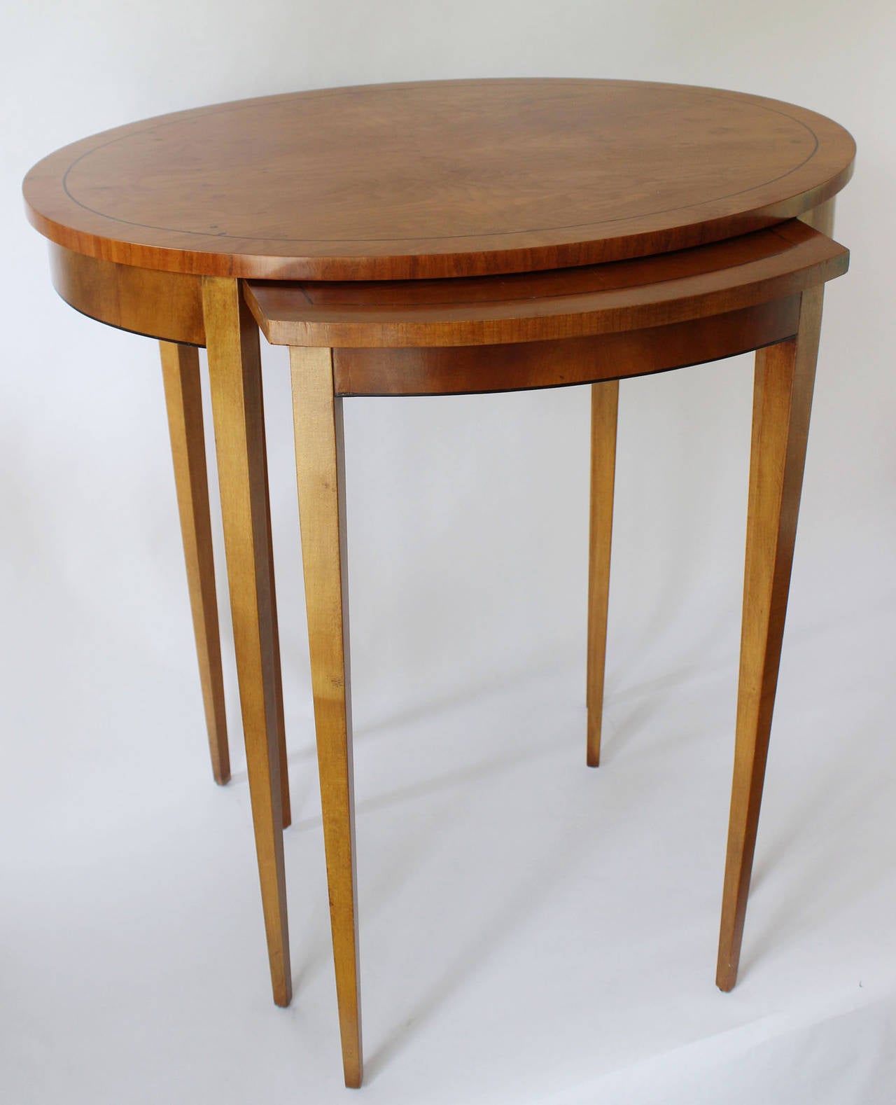 A pair of Burled walnut nested side tables by Baker.