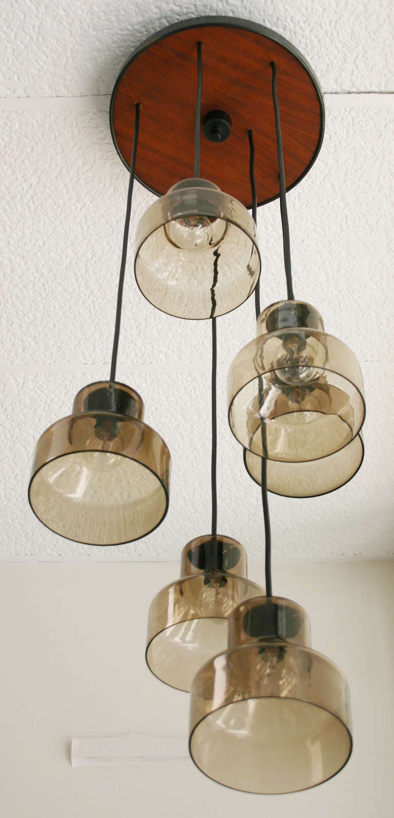 Handsome Danish pendant consisting of six smoke glass lamps hung from black enamel and teak ceiling 14" diameter framework.