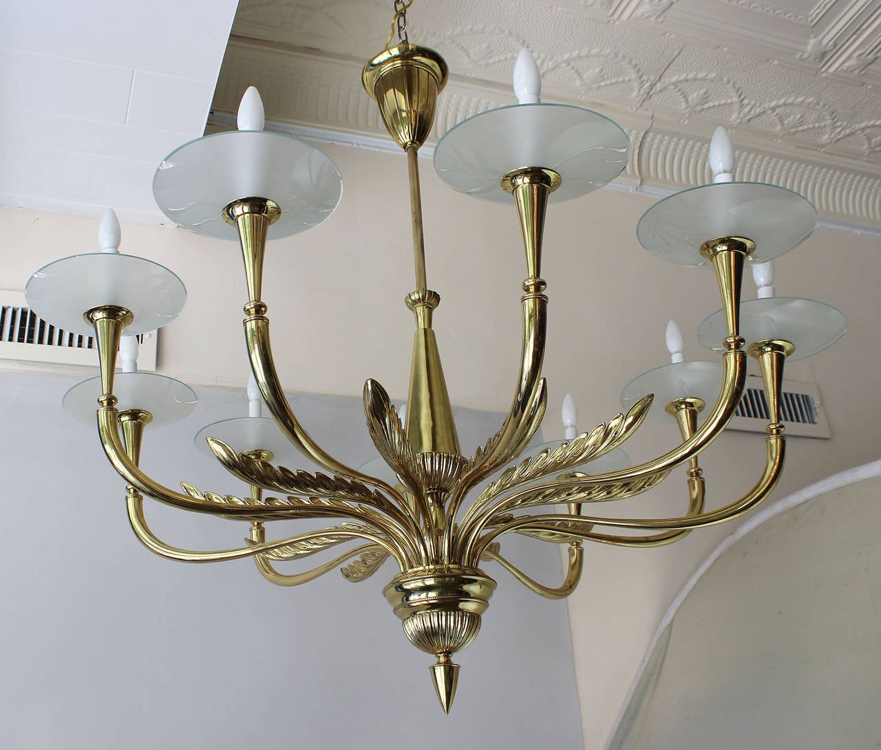 A magnificent regency style brass chandelier with leaf details and acid-etched glass dishes.