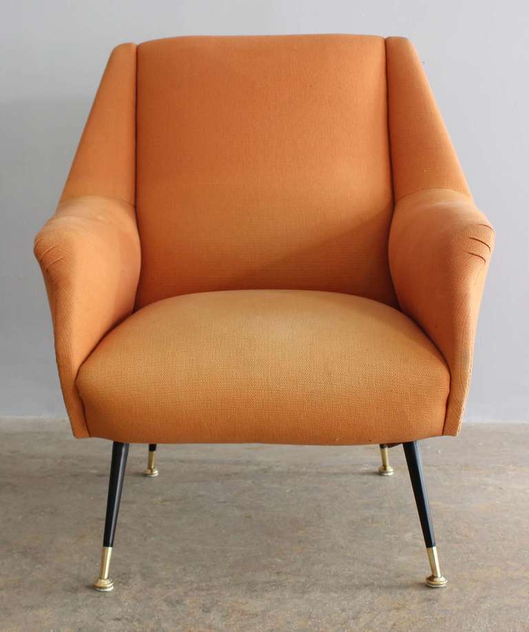 A modern Italian armchair with enameled metal and brass legs, in vintage original tailored upholstery.