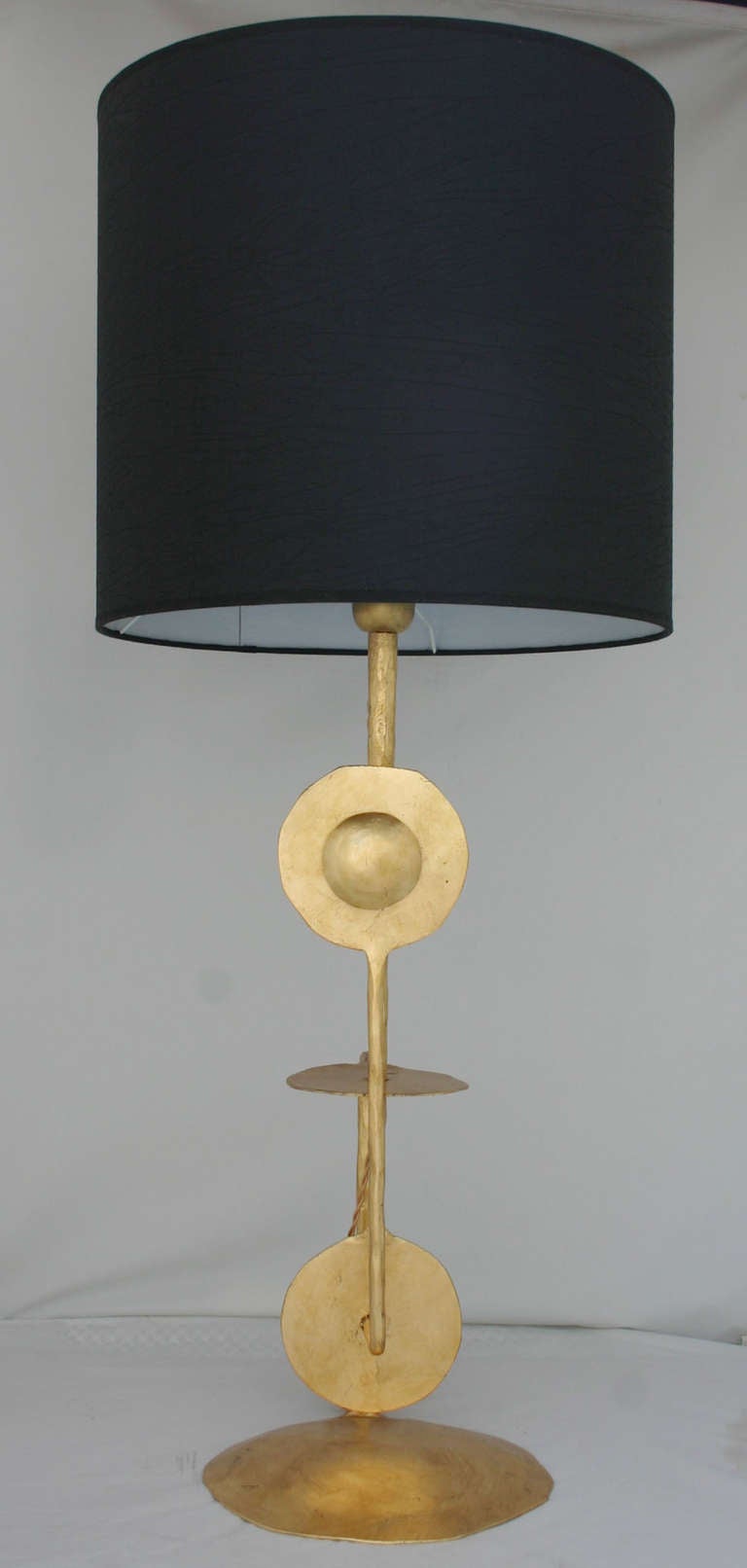 Stunning limited edition, sculptural pair of gilded, wrought metal lamps with black shades. wired and working.<br />
<br />
base is nine inches.