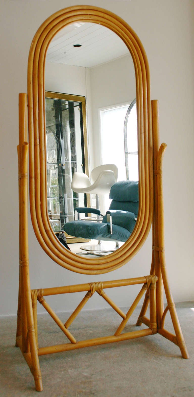 A freestanding, deco-modern, cantilevered, swivel mirror in the manner of Paul Frankl, by Harvey Schwartz of Tropical Sun Rattan.
