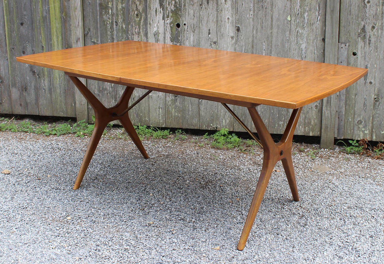 A walnut  dining table with brass support details and subtle curves, by J.O. Carlsson, Vetlanda, Sweden. 

Opens up to 103 inches for leaves (not included).

complimentary delivery within 30 miles.