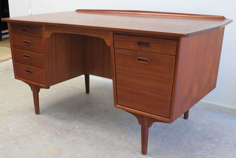 Smoothly contoured six drawer teak desk with back shelf storage by Svend and Madsen.