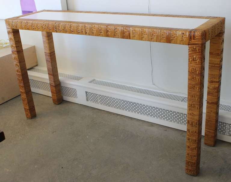 Long legged woven rattan console with white formica top.