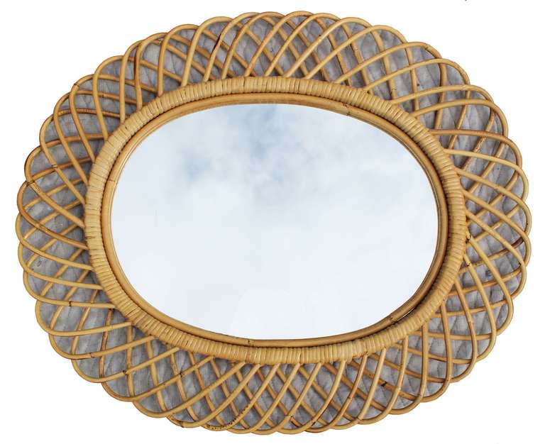 An oval rattan mirror in the manner of Franco Albini.