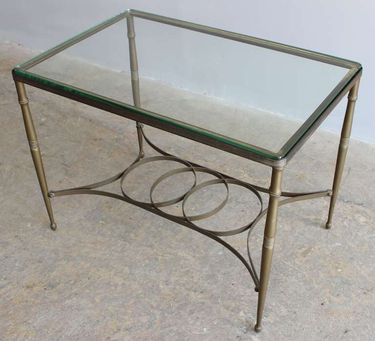 A handsome modern neo classical style patinaed brass side or end table with glass top.