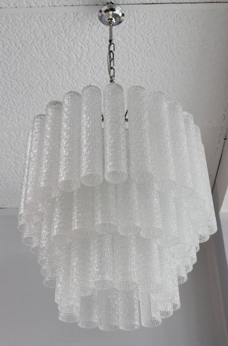 An elegant three tier chandelier with embossed Murano glass tronchi tubes, on chrome frame.  Each tube is 10.25