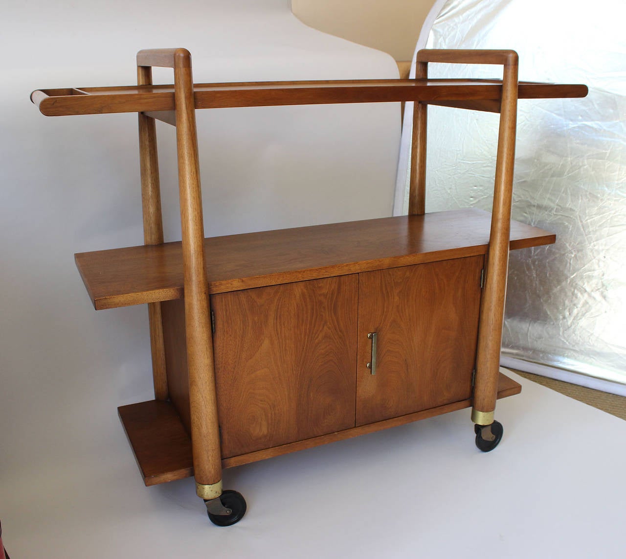 A very solid and functional rolling server cart, which can also serve as a console with patinaed brass hardware, by T.H. Robsjohn-Gibbings.

complementary delivery within 30 miles.