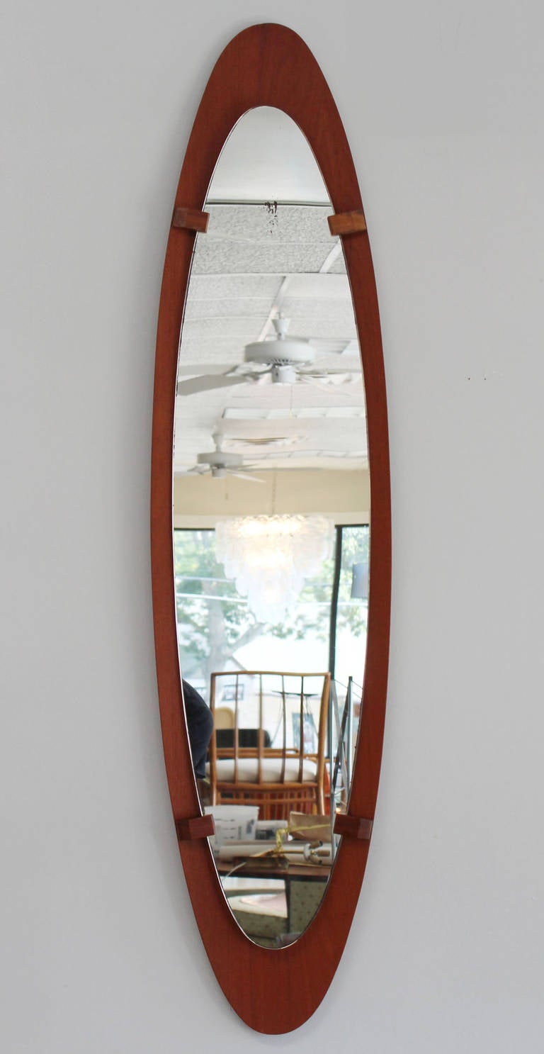 Elliptical teak frame mirror with wood stays holding elliptical mirror.