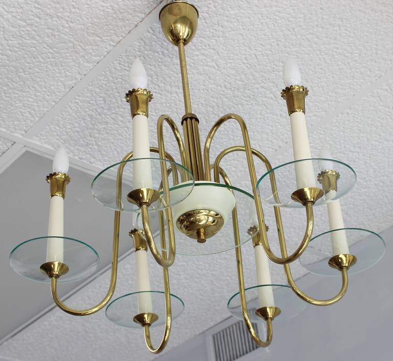 A six arm brass chandelier with enameled wood candlesticks, in the manner of Fontana Arte.
