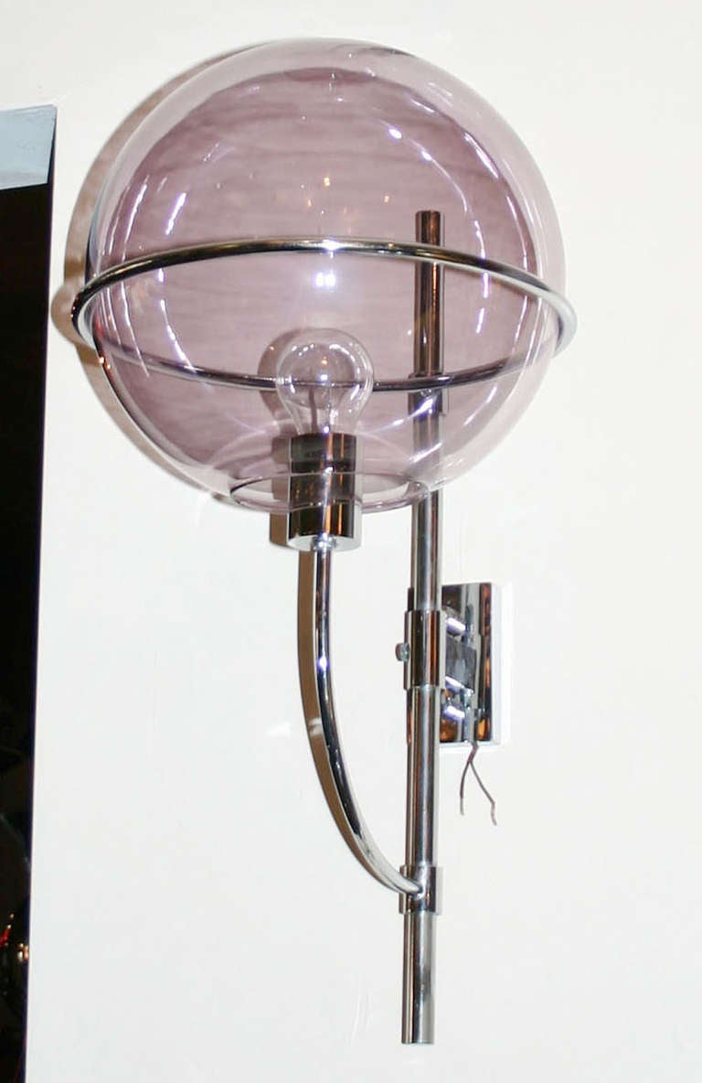 Designed in the 1970's by Vico Magistretti for O-Luce, the Lyndon wall light is a stylish modernist classic. Spare chromed structure, translucent violet glass 12 inch globe.