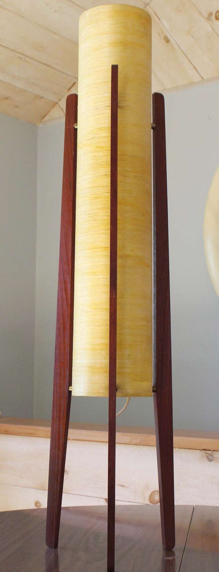 Teak frame rocket lamp with spun plastic cylinder shade and brass details.

newly wired.