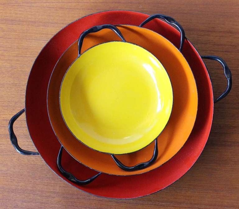 Brilliantly hued enameled metal nested bowls with black exterior, in the style of Catherineholm, Norway.