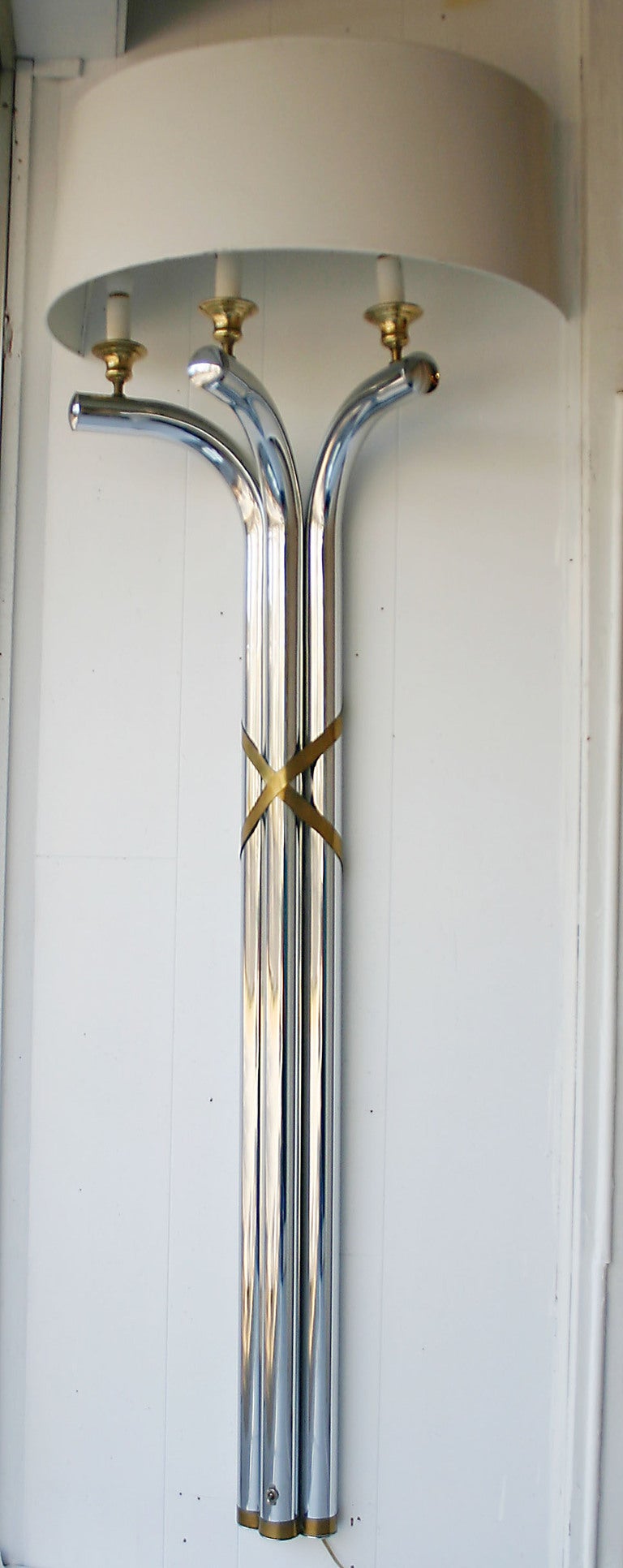 Pair tubular chrome regency wall mounted sconce/lamps with brass details in the style of Maison Jansen.