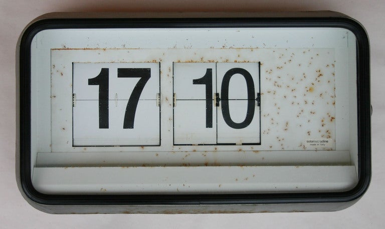 Early station flip clock designed by self-taught engineer Remigio Solari of Solari Udine, founded in 1948. Alphanumeric characters and text onto metal flaps attached to a wheel mechanism, and enclosed within a glass top display with metal frame.