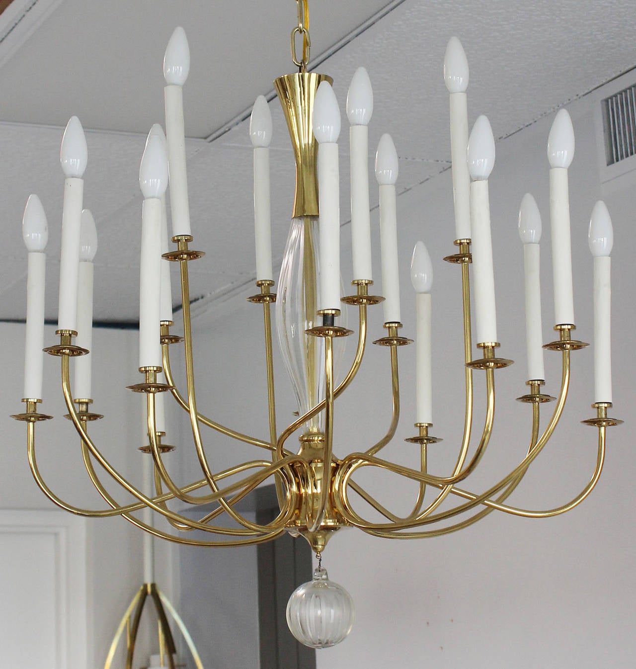 A regency style eighteen arm brass chandelier with Baccarat crystal details.