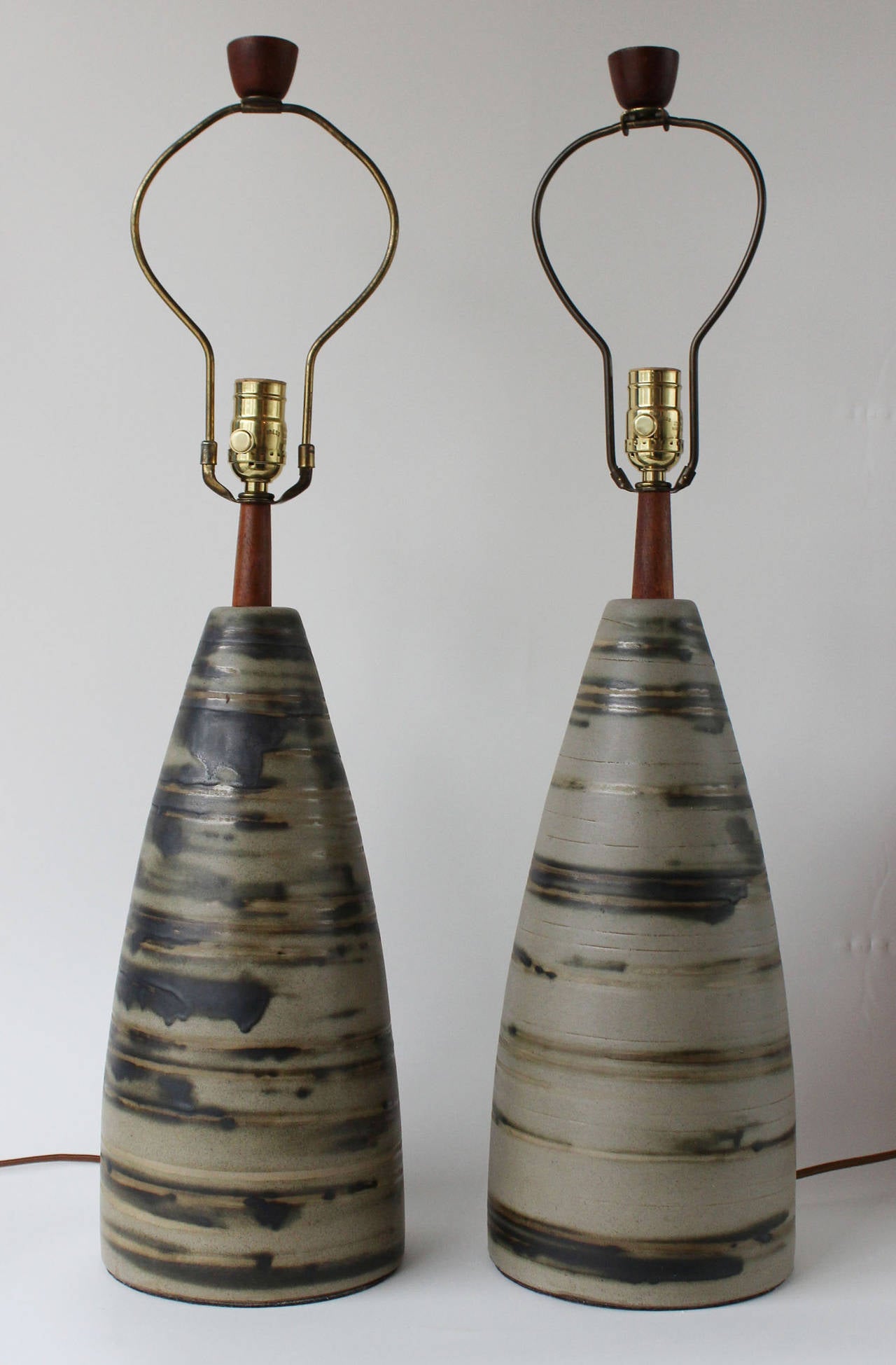 A pair of glazed ceramic lamps with teak neck and finial details by Jane and Gordon Martz for Marshall Studios. 

18.5