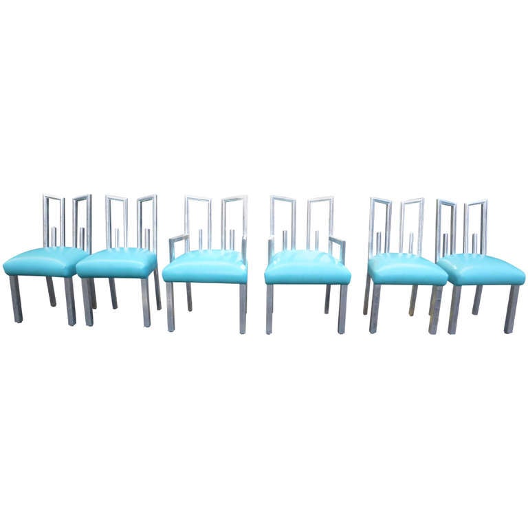 A set of six patinated silver leaf dining chairs by James Mont, c 1940s. Each chair has open elongated Greek Key back. The newly upholstered soft blue leather seats sit on four square legs. Finished in original silver-leaf over black, the chairs are