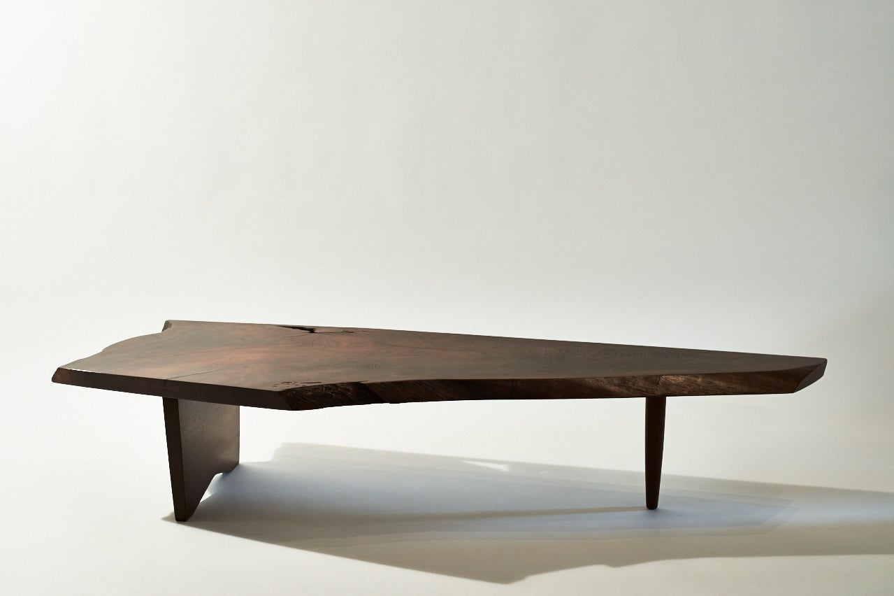 This outstandingly sleek and organic Black walnut slab low table features a beautifully figured top with the wood’s natural inclusions. One on side, there is a rare, 12” long-butterfly. The table is accompanied by the original receipt from the