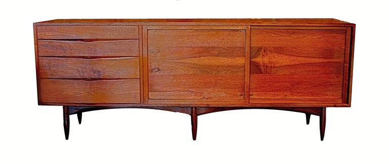 A very early (circa 1955) full size - seven foot credenza by Phillip Lloyd Powell made in New Hope, PA. The console/credenza represents one of the earliest full size pieces by PLP.  The case sits on six gracefully proportioned legs, features a bank