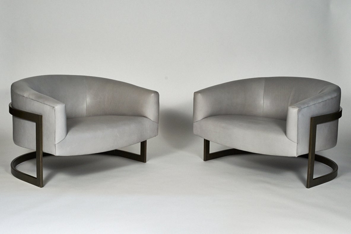 A pair of oversized Milo Baughman lounge chairs upholstered in Dior grey leather. The elegant dark bronze frames are in their original finish. This outstanding design arguably makes for one of Baughman's best chairs. Their generous proportions