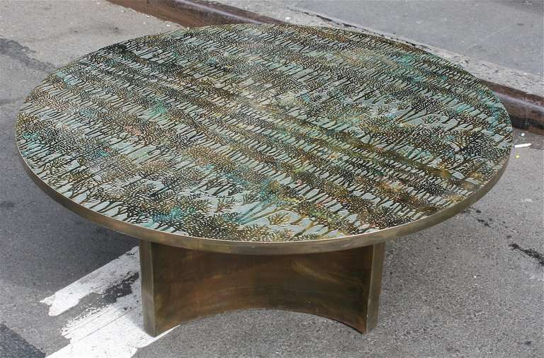 An exceptional and rare low table by Philip and Kelvin LaVerne with an intricate design of trees, circa 1970, USA. The table is constructed from thin layers of bronze over pewter and has a circular-shaped top sitting on a four-point curved support.