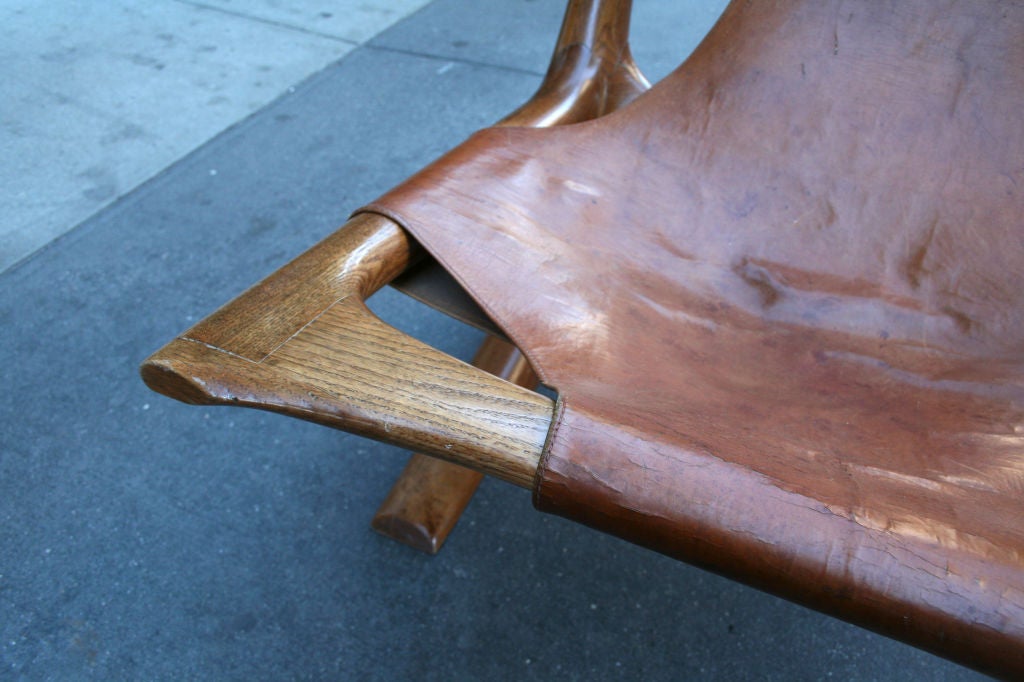 A carved oak and leather lounge chair by J. Muckey. Carved signature: 