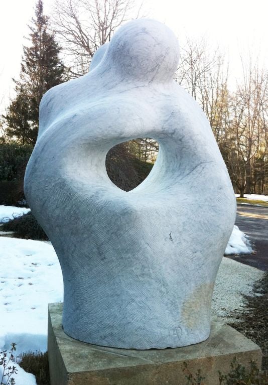 A monumental marble sculpture by Arturo DiModica (b. Sicily, 1941). This sculpture has the abstract form of two figures embraced. The marble is finished roughly with some visible carving marks. This sculpture is suitable for outdoor display. The