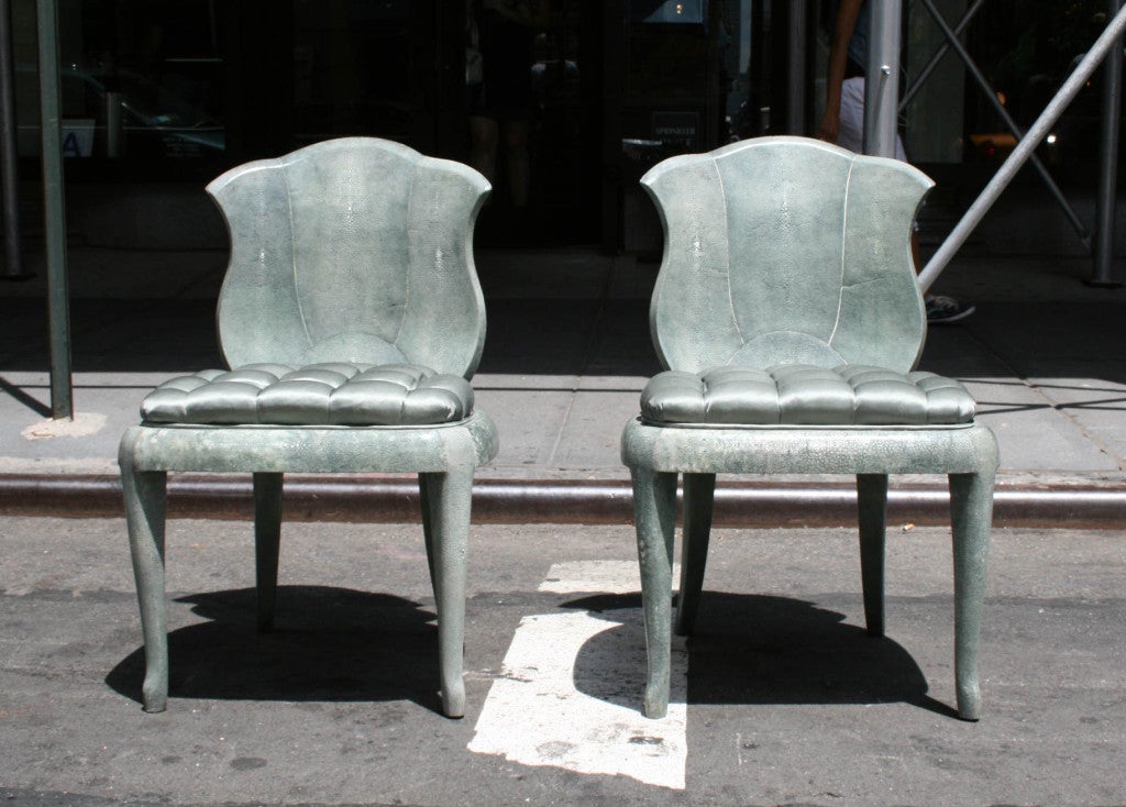 A pair of elegant green shagreen chairs, bearing a sunburst pattern on the back and upholstered in silver-green silk. Their gorgeous form and expert execution could have only come from the hand of a very fine craftsman. These chairs were made