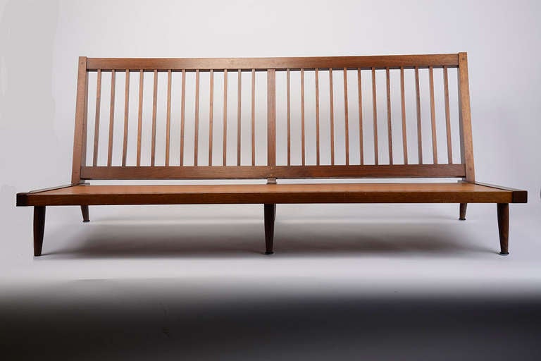 Low Settee in American walnut, hand crafted by George Nakashima circa 1960's. Simplistic armless form with squared spindled back and legs with visible dowels.

 
Settee is in Excellent condition.

 
72.5'' L  x  32'' D x  30.5'' H