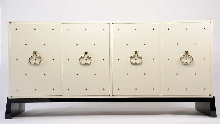 Studded Console by Tommi Parzinger for Parzinger Originals, USA, 1960

Brass studded Console by Tommi Parzinger for Parzinger Originals. White lacquer set with bronze studs and solid brass hardware on walnut base. Four doors open to reveal a