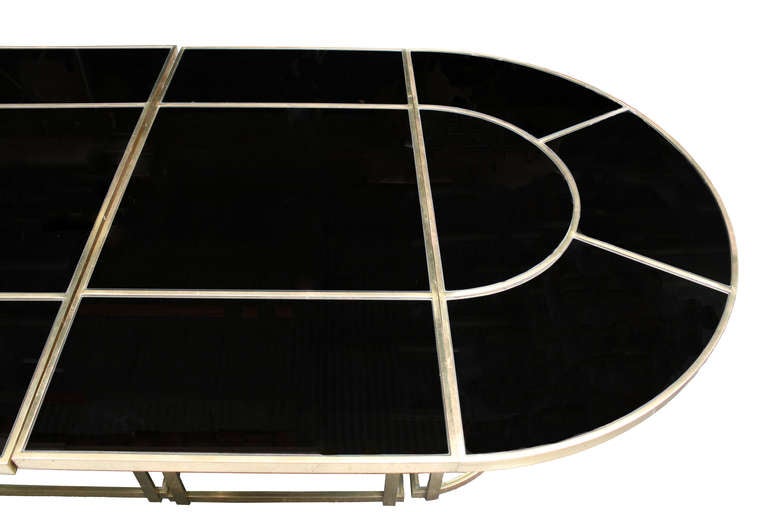 Bronze and grey smoke mirror dining table in four sections in the style of Gabriella Crespi, made in Italy, circa 1970s.

A large oval bronze and grey smoke-mirrored dining table. The glass is segmented and on the upper and lower level. Sections