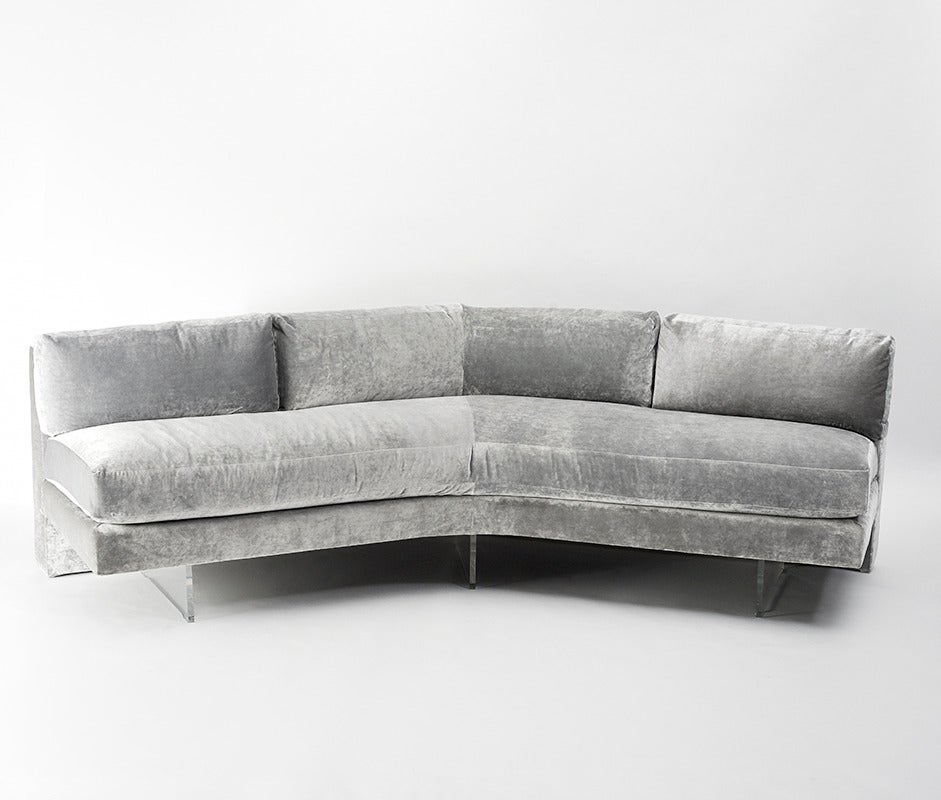 Comprised of two parts, the sofa may be arranged as one large piece as pictured or with two sections of which one features a slight V-shape and curve the other an L-shape lounge (pictured separately below). Newly reupholstered in beautiful Romo grey