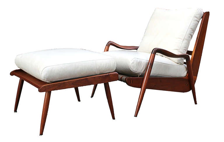 An early Studio New Hope Lounge Chair and Ottoman sculpted in American Black Walnut, reupholstered in parchment off-white matte leather, original webbing in tact. Excellent Condition.

Ottoman in solid wood with loose cushion.