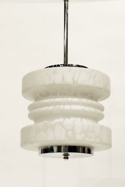 Pendant fixture in abstract spool design of white-on-white art-glass from Murano. Chromed steel caps bottom and top, with chromed steel stem.