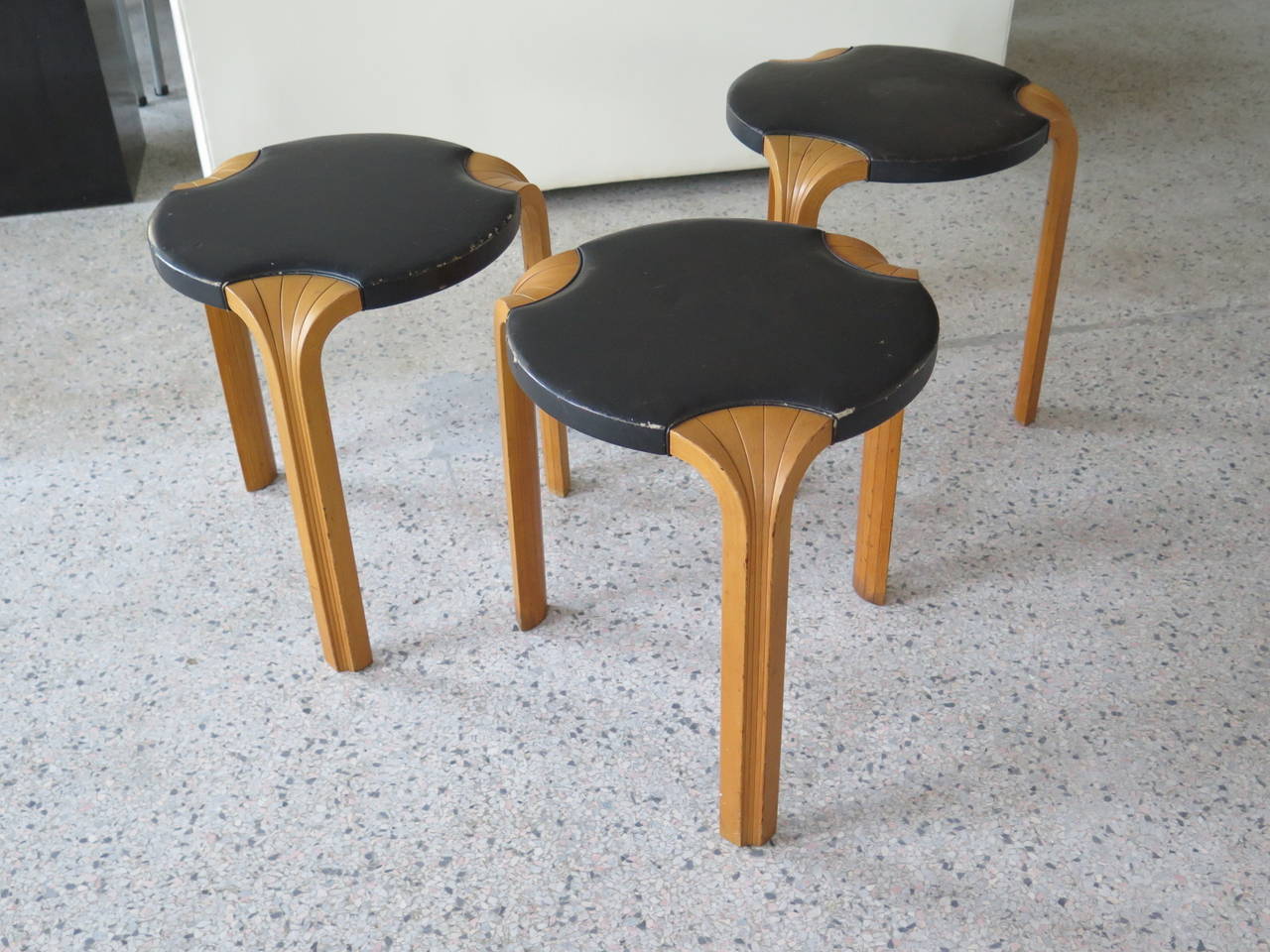 A Classic fan leg stools by Alvar Aalto, circa 1960s. Original dark brown leather.