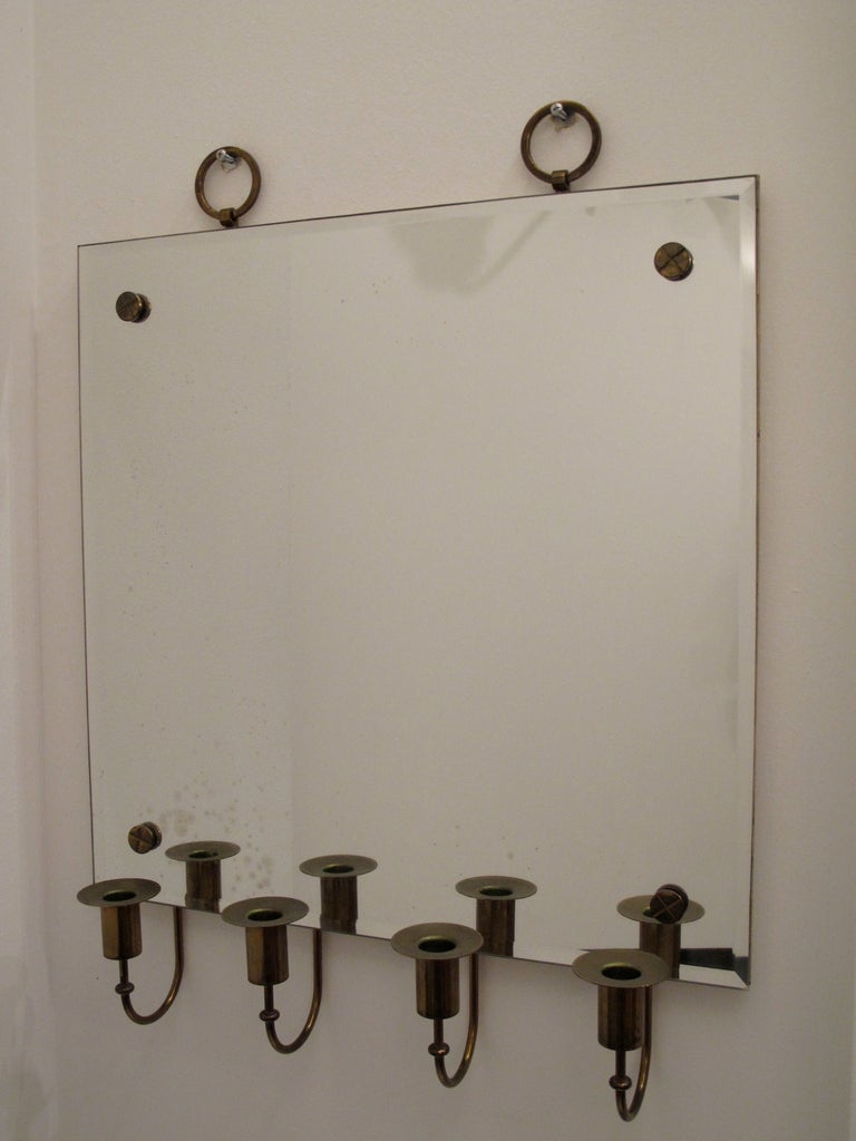 A great mirror by Tommi Parzinger for Charak Modern, circa 1950s.
Brass candleholders, large decorative ring handles, brass X-details.