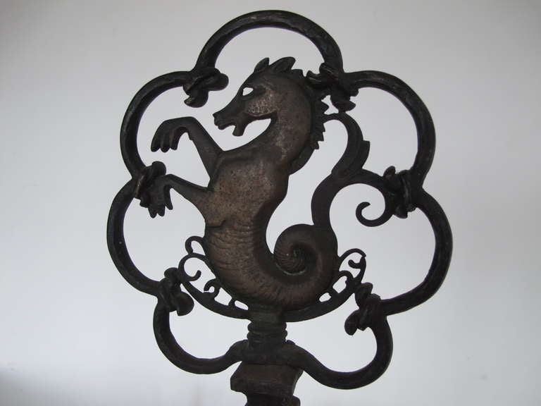 A pair of stylized, sea-horse andirons by Oscar Bach.