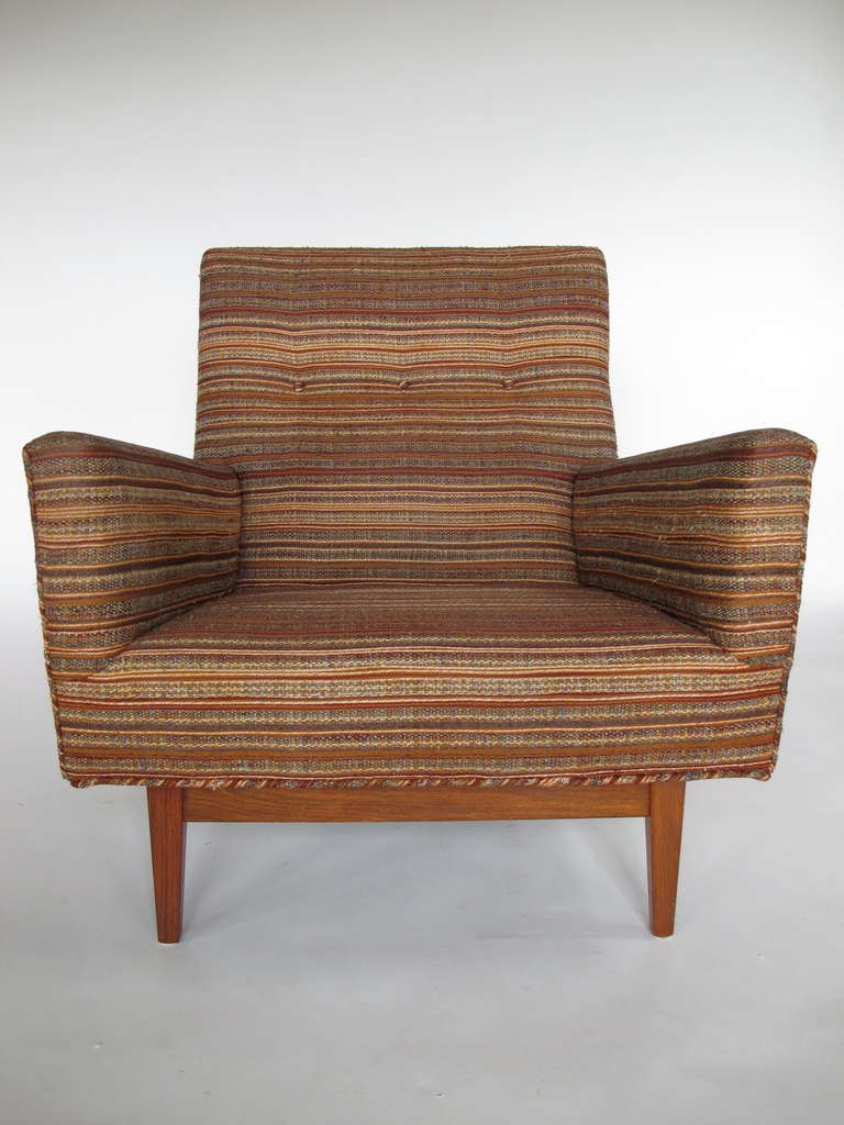 A pair of classic Jens Risom upholstered lounge chairs. Walnut frames. Vintage fabric.