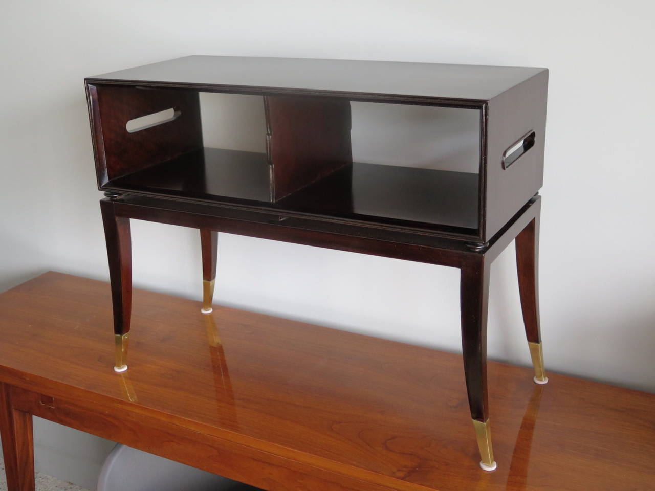 Rare Tommy Parzinger magazine table with handles on the sides and brass sabots. Designed for Charak Modern, circa 1950s, mahogany.