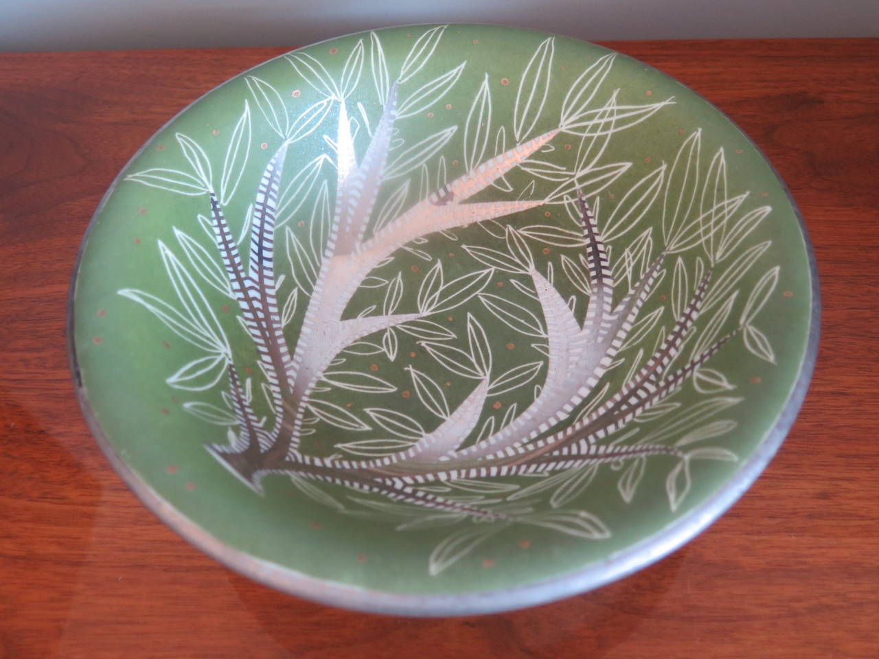 An elegant, hand-painted bowl by Waylande Gregory. Stylized leaf pattern in green and silver leaf.