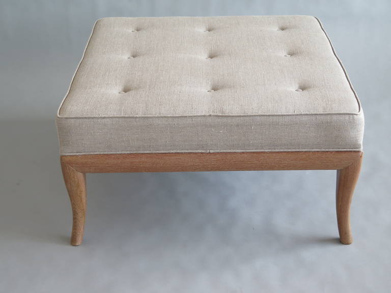 A large, elegant ottoman in the style of T.H. Robsjohn-Gibbings. Cabriolet legs with new cerused finish, new light grey upholstery.