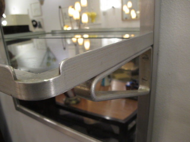 An unusual, large mirror from the famed SS United States luxury liner. A piece of history, yet very practical with attached shelf. Aluminum with brushed finish and a clean, modern look.