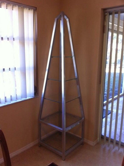 Un'elegante etagere, a forma di obelisco, in alluminio lucido, con ripiani in vetro, nello stile di Milo Baughman.