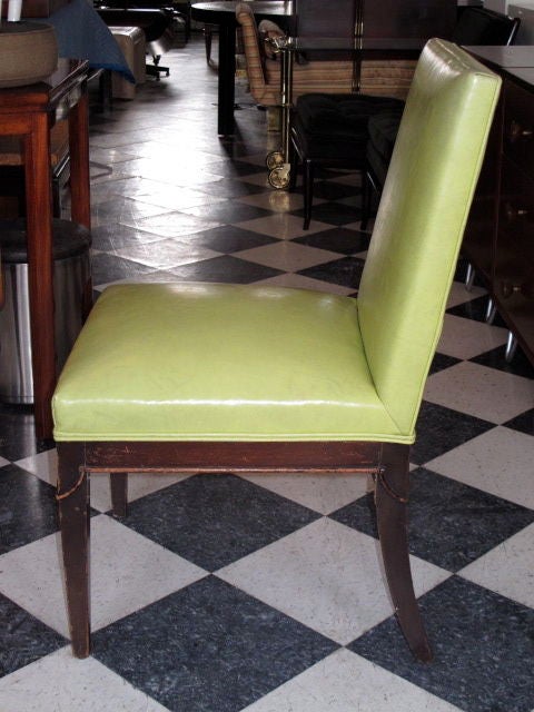 Un ensemble de quatre chaises à manger élégantes de Grosfeld House. Sellerie d'origine en cuir vert lime, notez les pieds sabres arrière, avec de subtils détails décoratifs. Le prix comprend la restauration selon les spécifications du client -