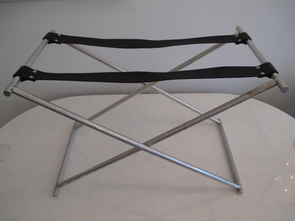 An unusual folding table, machined aluminum and heavy leather straps.