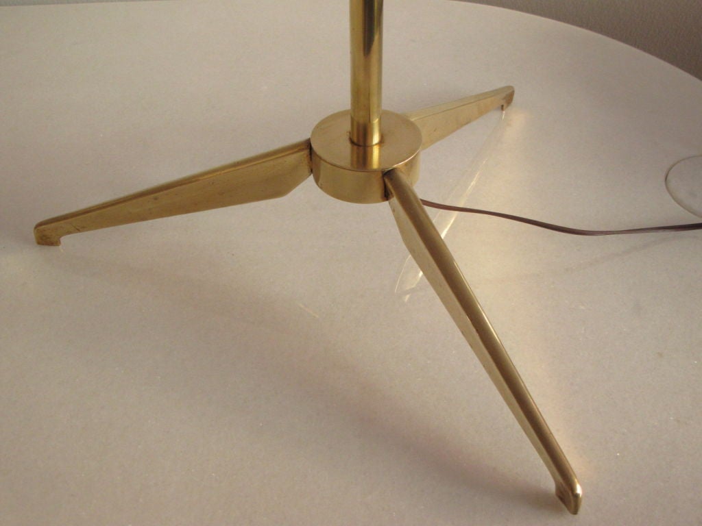 An elegant brass torchere by Stilnovo (Italy), ca' 1950's. Tripod base, oplaine glass shade with brass trim.