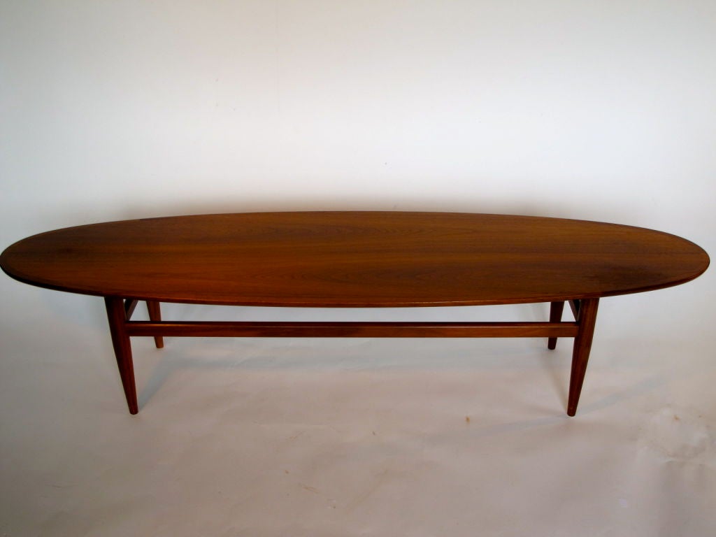 An elegant, modernist surfboard coffee table by Heritage in walnut.