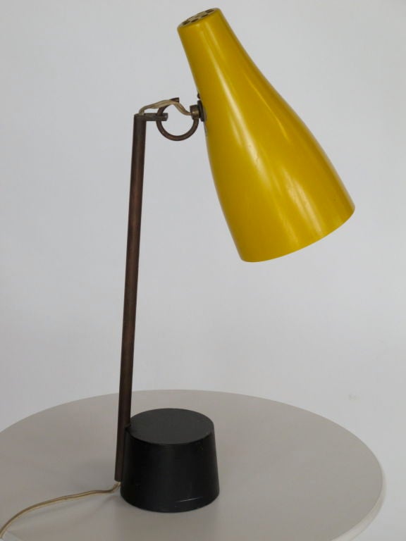 A rare, modernist table lamp by Kalmar, 1950's. Yellow shade on adjustable eye hook, heavy pot shaped base. From estate of George Kovacs, the lighting designer.